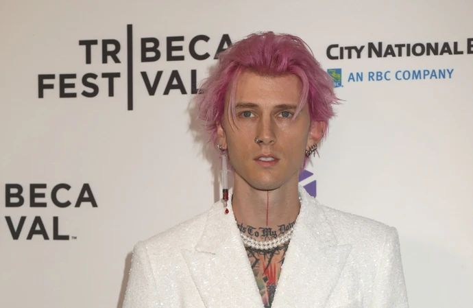 Machine Gun Kelly narrowly avoids falling from helicopter prop