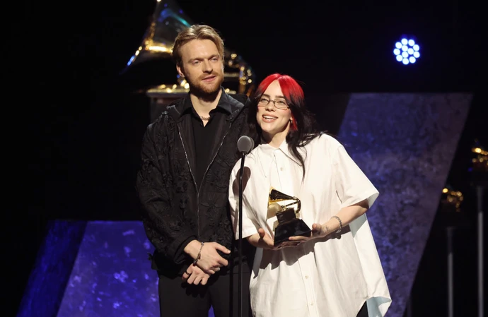 Finneas O'Connell and Billie Eilish collecting their Grammy Award