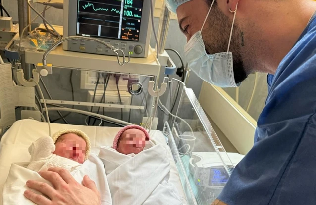 Andreas Muller emozionato insieme alle gemelle neonate