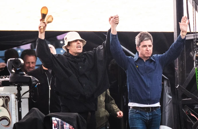 Oasis stars Liam Gallagher and Noel Gallagher on stage at Murrayfield Stadium in Edinburgh