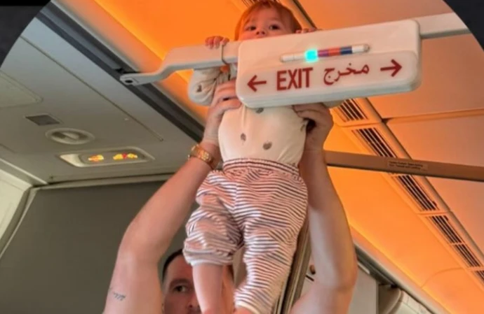 Charlotte Crosby edited her fiance Jake Ankers out of this photo, making it appear Pixi was dangling from a plane's fire exit sign herself / © Instagram