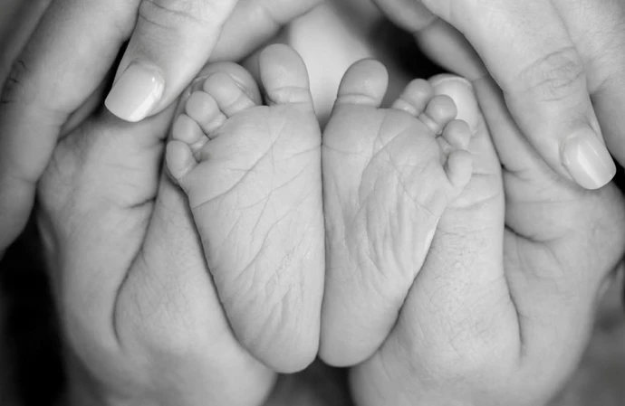 Derek Hough and Hayley Erbert's hands cupped around their first child's feet / © Instagram