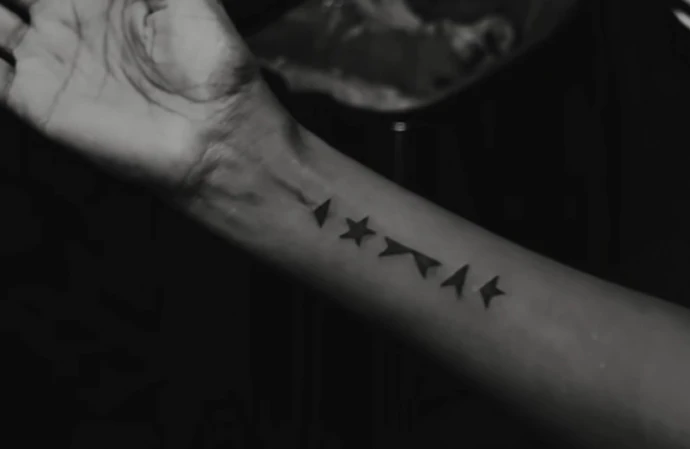 Iman has the five minimalist rune-like black shapes from the bottom of David Bowie's final album, Blackstar, tattooed on her forearm / © Instagram
