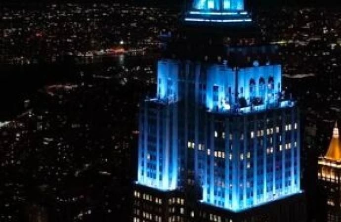 The Empire State Building is lit up in blue
