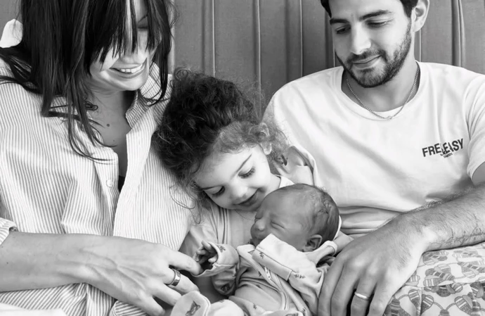 Daisy Lowe, Jordan Saul, and Ivy bonding with the new addition to their family / © Instagram