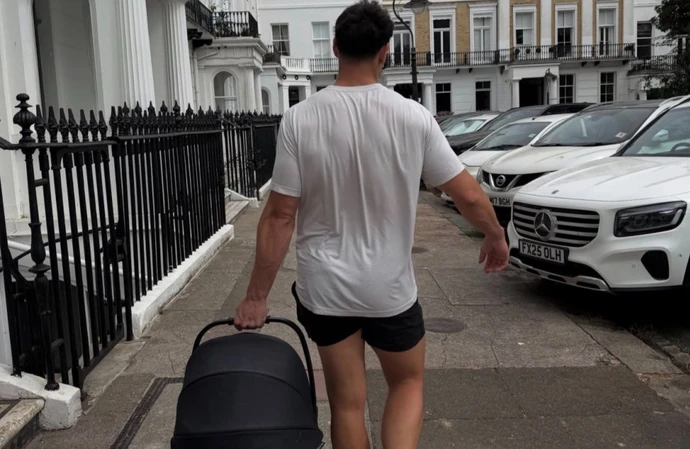 Love Island's Jay Younger carrying his newborn in a baby carrier in the street / © Instagram