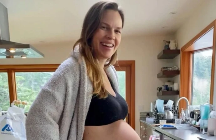 Hilary Swank has revealed she is expecting her third child at 52 – announcing the pregnancy with a glow-in-the-dark family dance featuring her husband and their three-year-old twins and joking her next big project is due for release in December